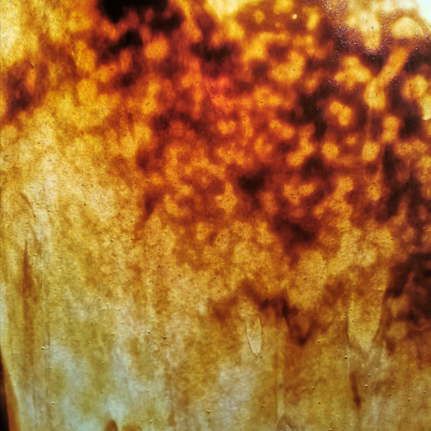 A photo of a brown and amber stained glass sheet.