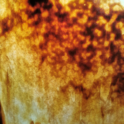 A photo of a brown and amber stained glass sheet.